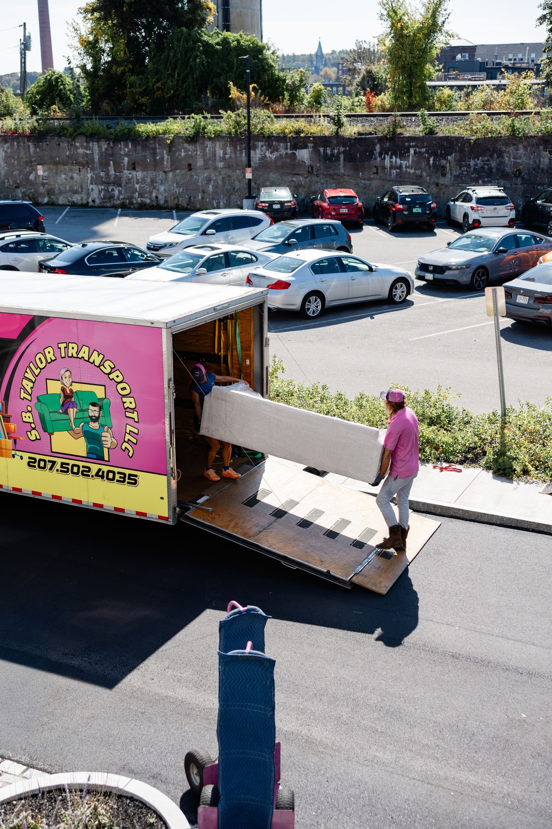 movers carrying a sofa out of the trailer
