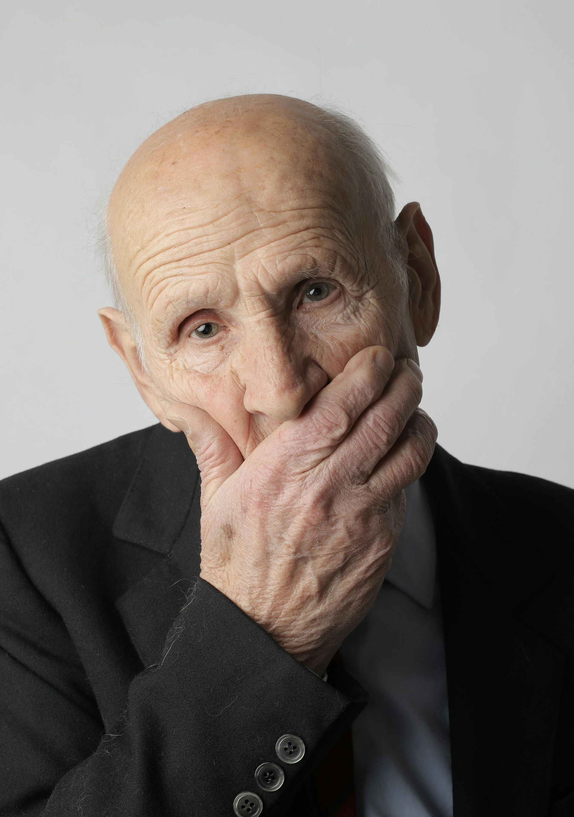 man hand over mouth sad