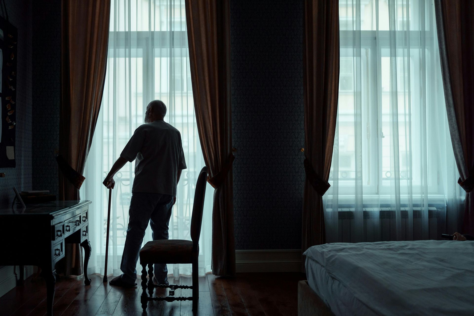 man standing alone looking out the window