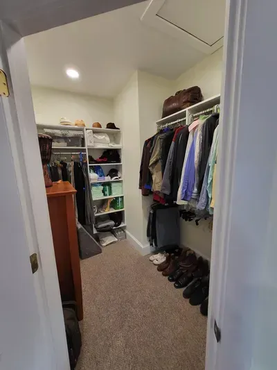 a walk in closet filled with clothes and shoes unpacked