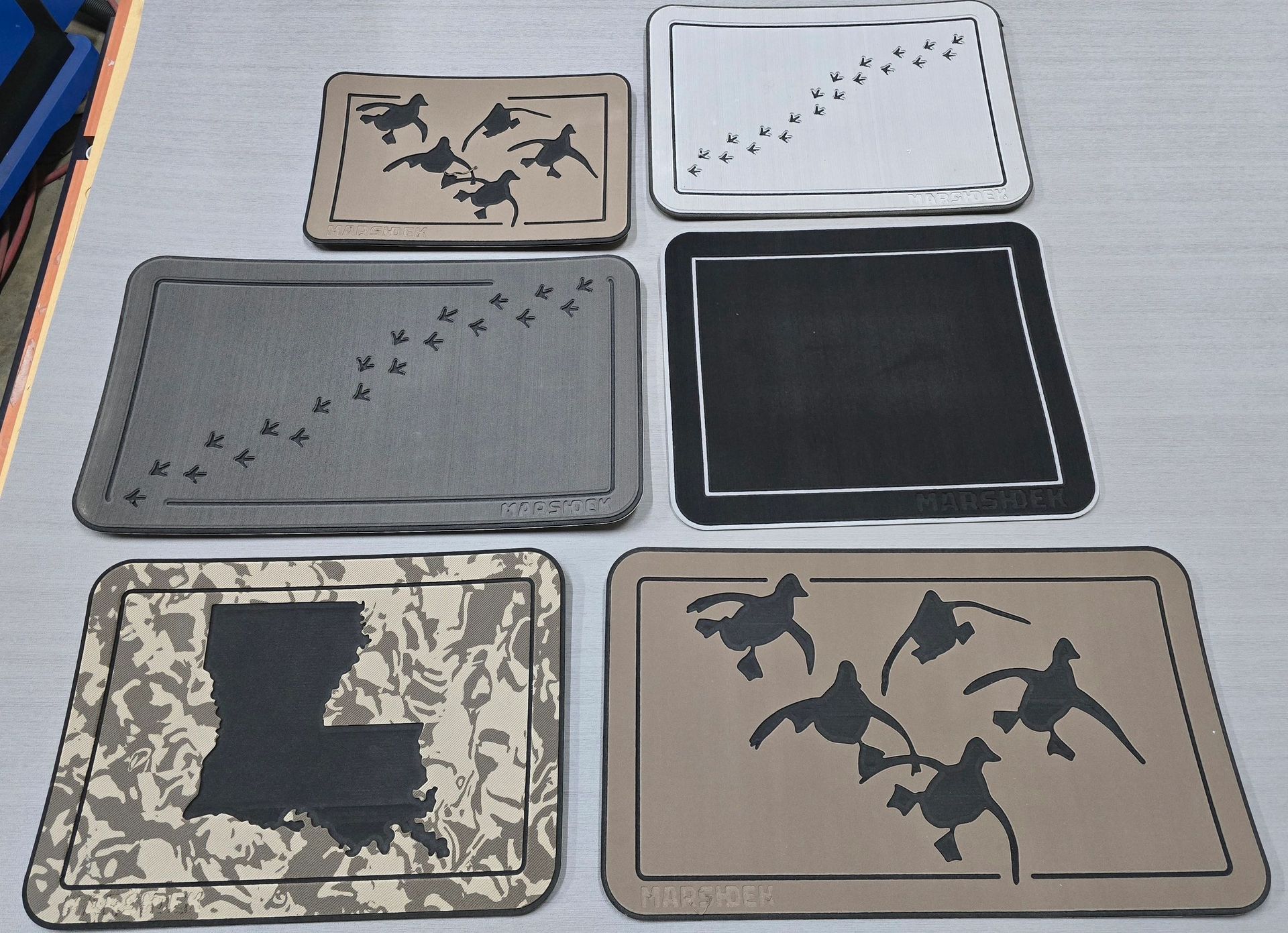 Six decorative rectangular boxes with varied black, tan, and camouflage patterns on a light surface