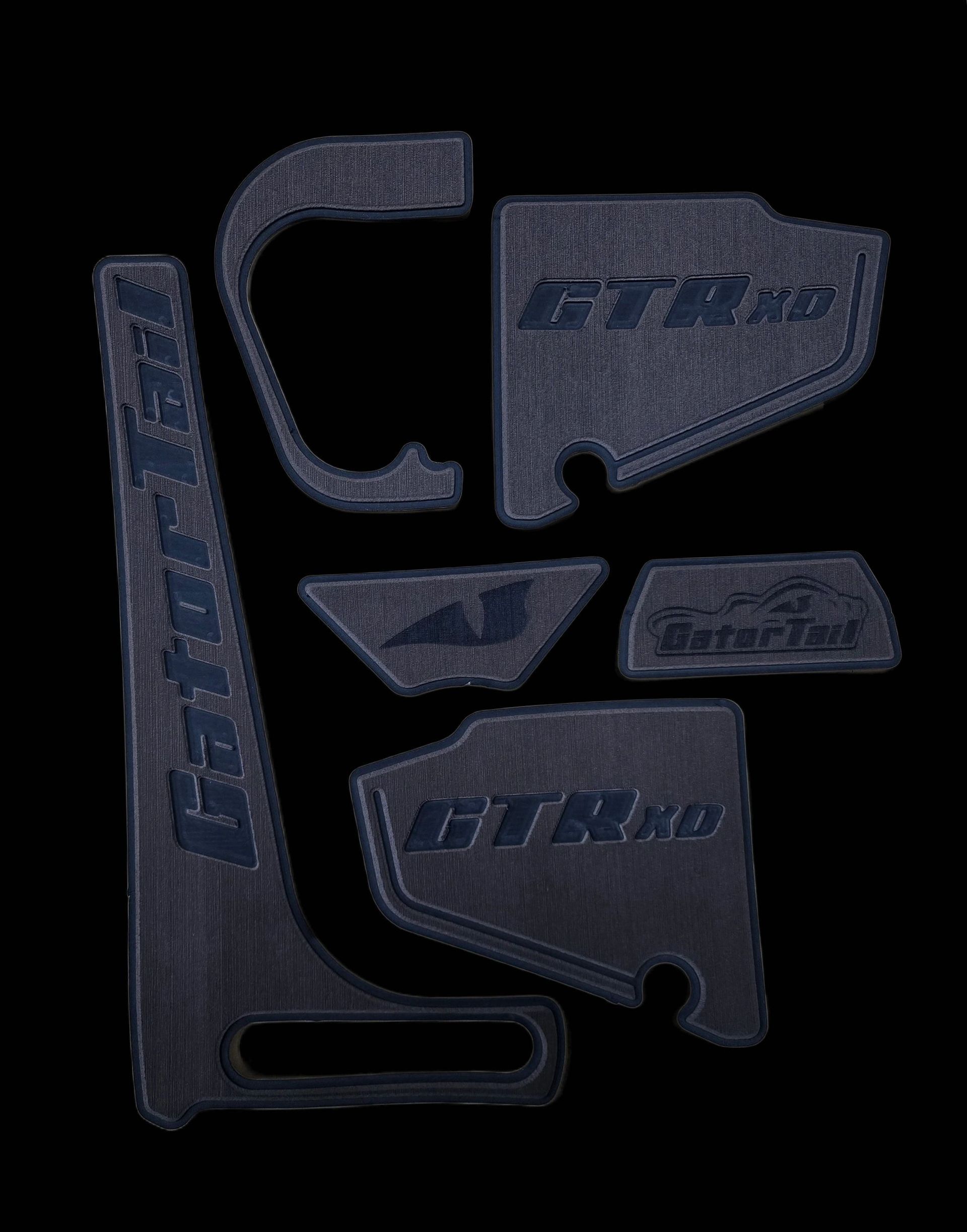 Dark blue plastic automotive trim pieces and clips arranged on a black background