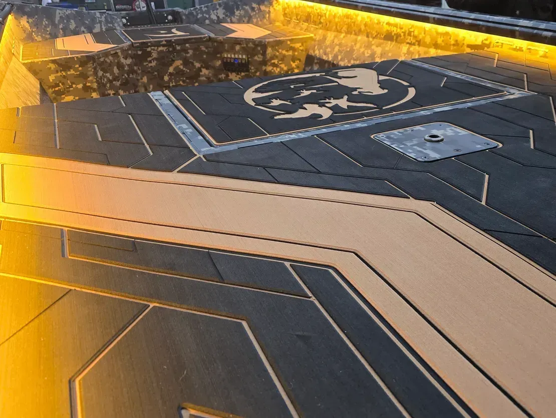 Golden-lit aircraft carrier deck with a helicopter landing pad marking and runway lines