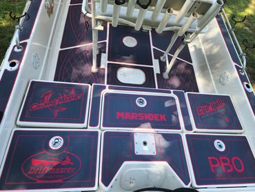 Boat deck with black and red custom hatches, panels, and marine hardware.