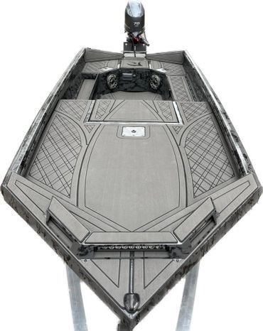 Top-down view of a gray motorboat with a small outboard motor and textured deck trim.
