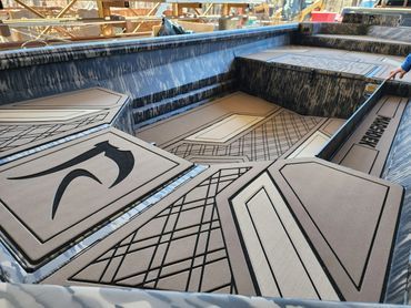 Geometric metal rooftop panels in gray and black, viewed from above, with an industrial city background