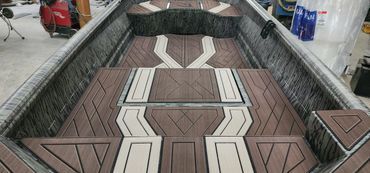 Patterned woven mat in an indoor showroom, with geometric brown, cream, and black designs.