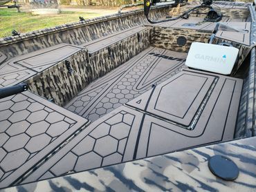 Concrete-lined empty pool with geometric tile patterns and a white box on the deck at right