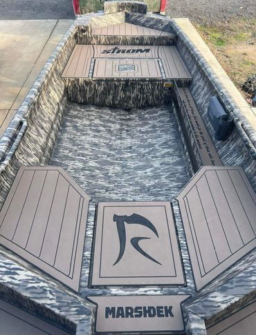 Outdoor decorative dock or waterscape with wood panels and a central logo reading 