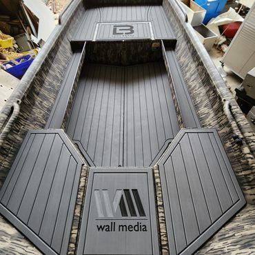 Top-down view of a gray, boat-like coffin or display tray with a center panel labeled “wall media”