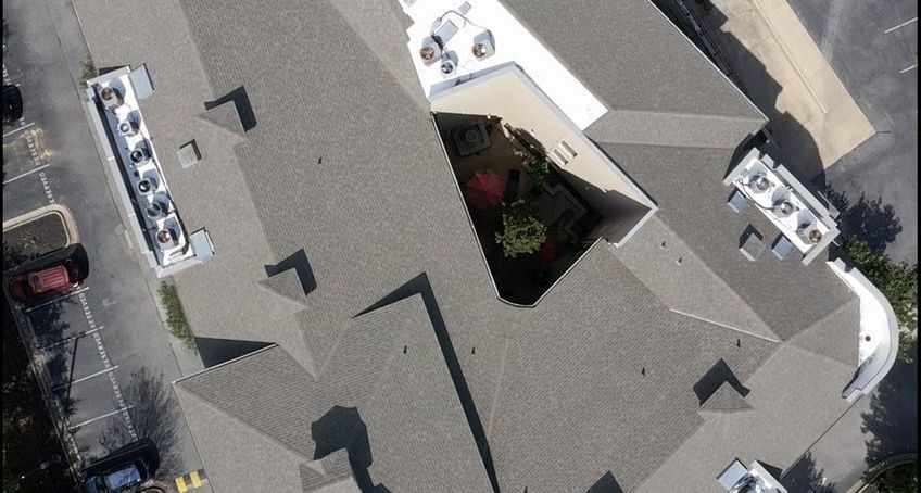 An aerial view of a large building with a white roof