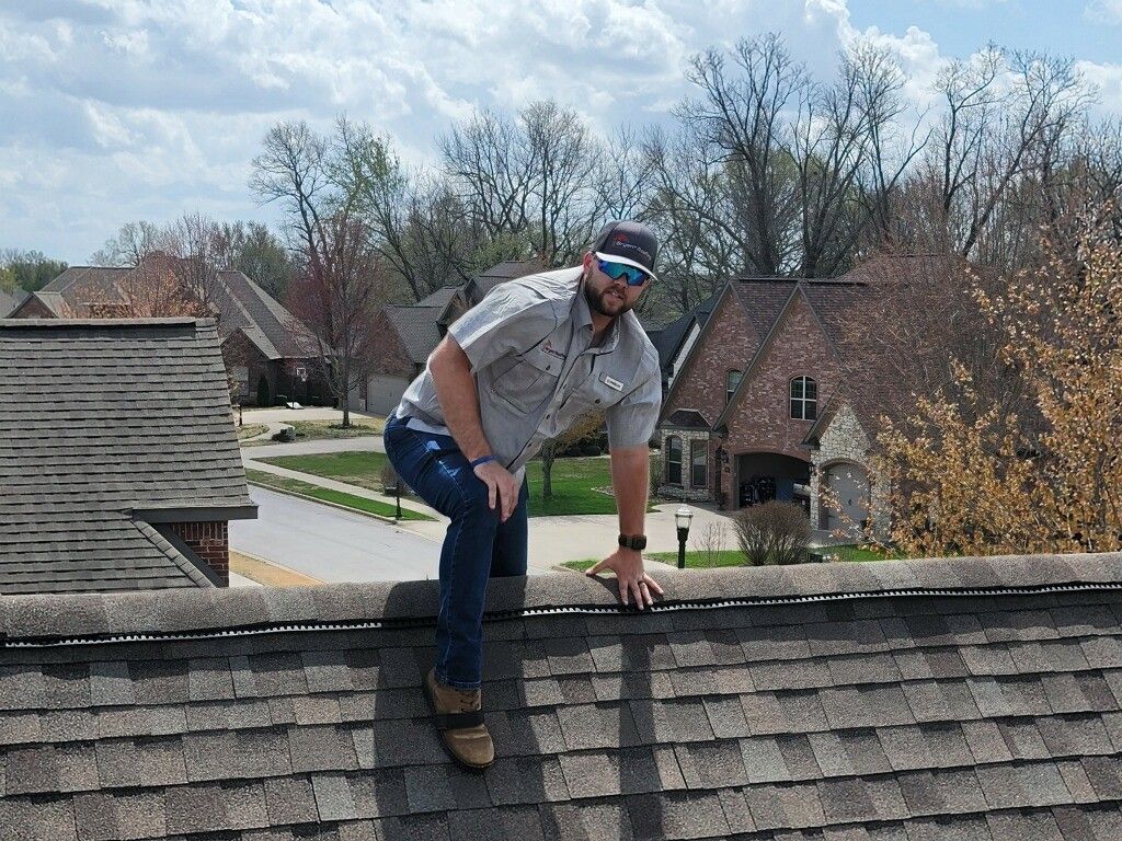 A man is standing on the edge of a roof.