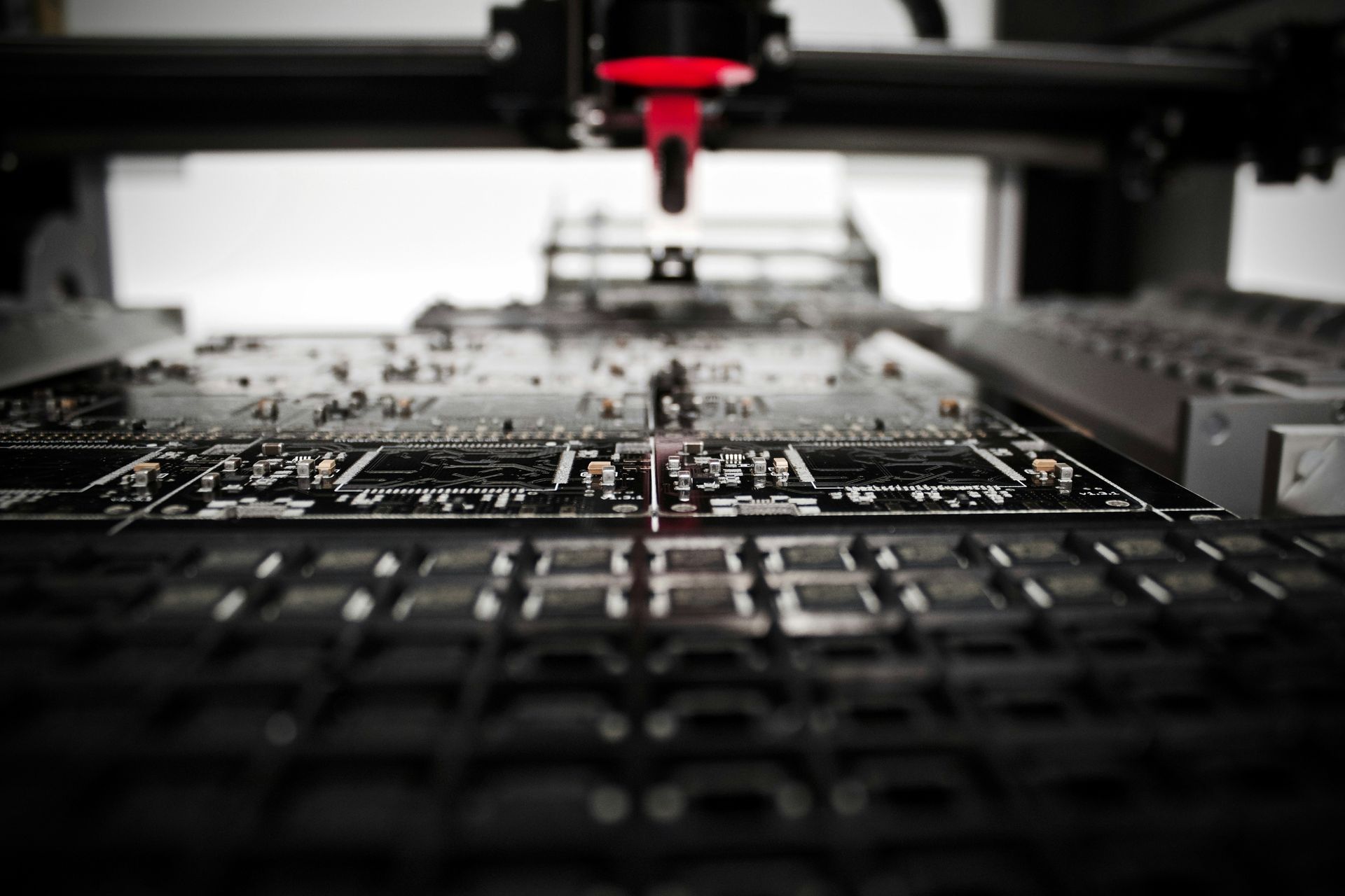 Close-up of a CNC machine engraving a circuit board with a red spindle head