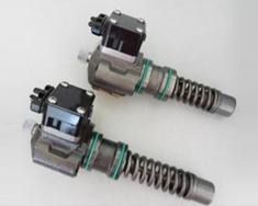 Dos solenoides automotrices plateados y negros con ejes metálicos accionados por resorte sobre un fondo blanco.