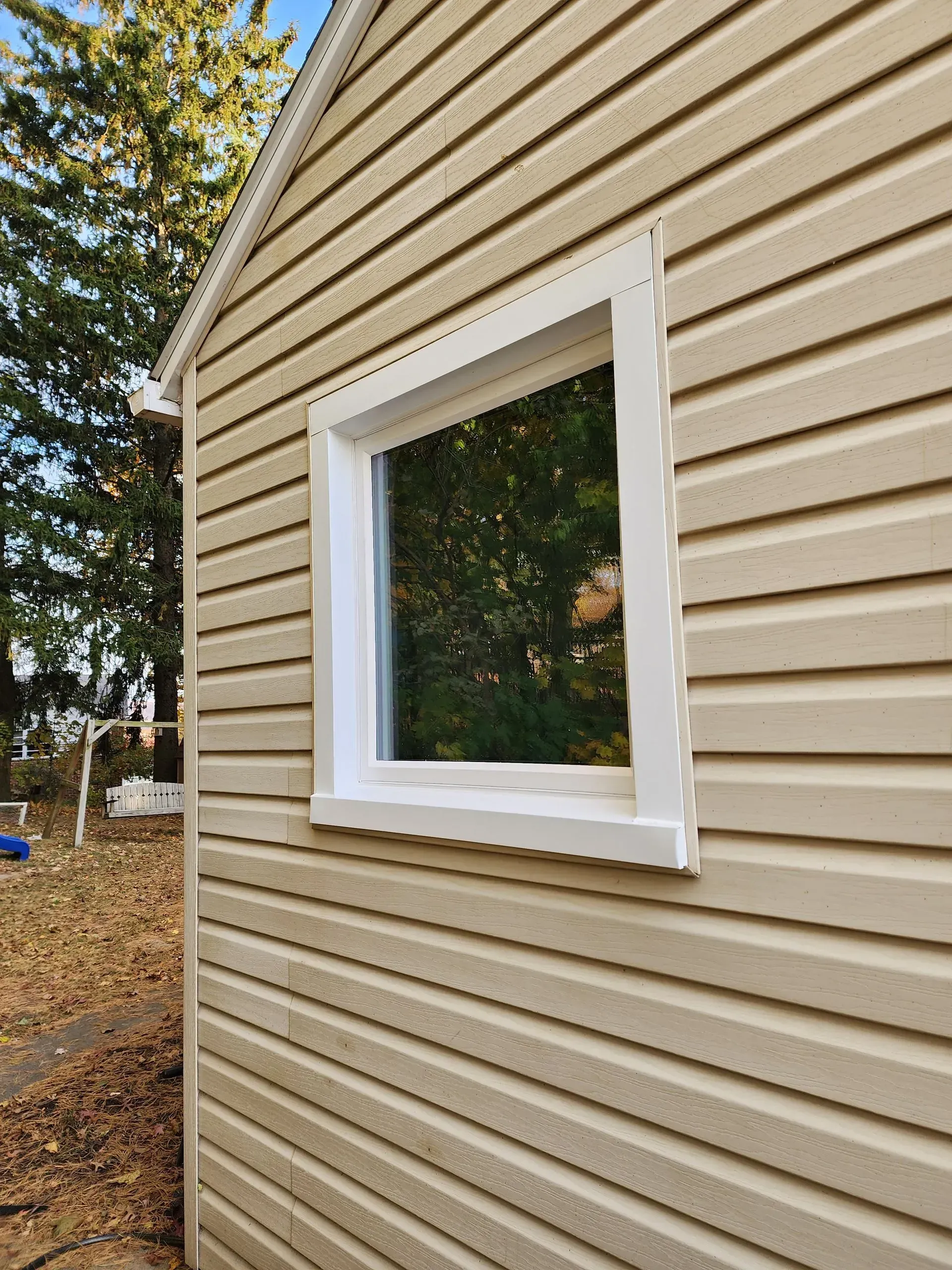 House siding with a white-trimmed window on an exterior wall.