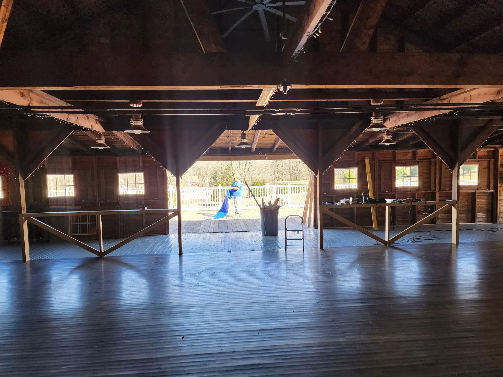 Empty wooden hall with beams and a bright open doorway in the center