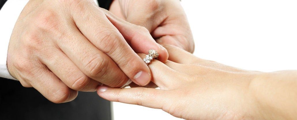 Hands placing a ring on another person’s finger