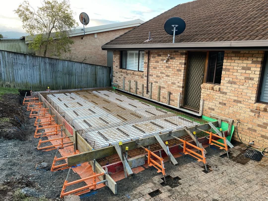 Backyard Patio with Fallen Metal Awning Frame Beside a Brick House — QBC Constructions In Kiama, NSW