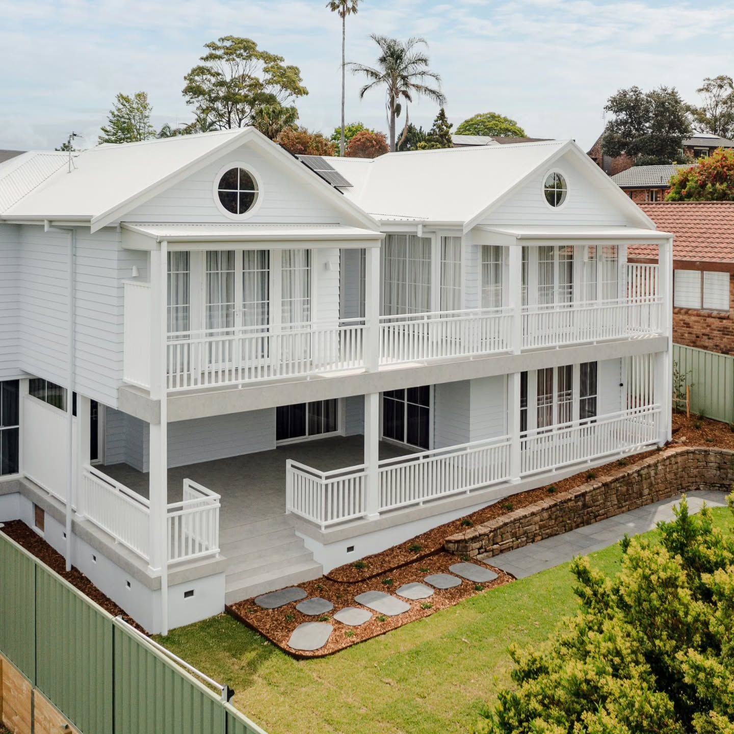 White Two Story House with Balconies and A Front Lawn Viewed from Above — QBC Constructions In Gerringong, NSW