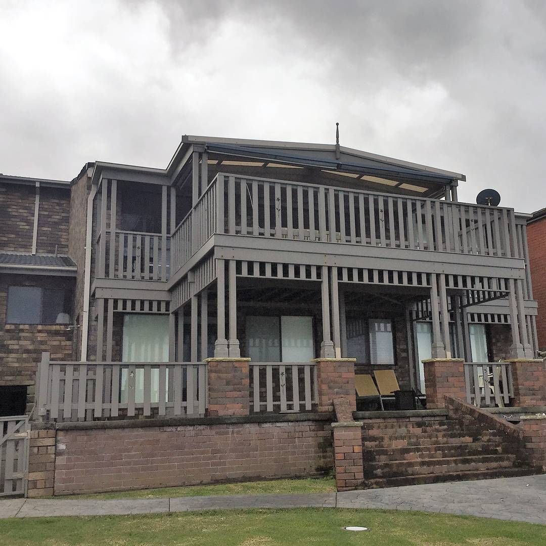 Weathered Two Story Wooden House with Balcony and Brick Steps — QBC Constructions In Gerringong, NSW