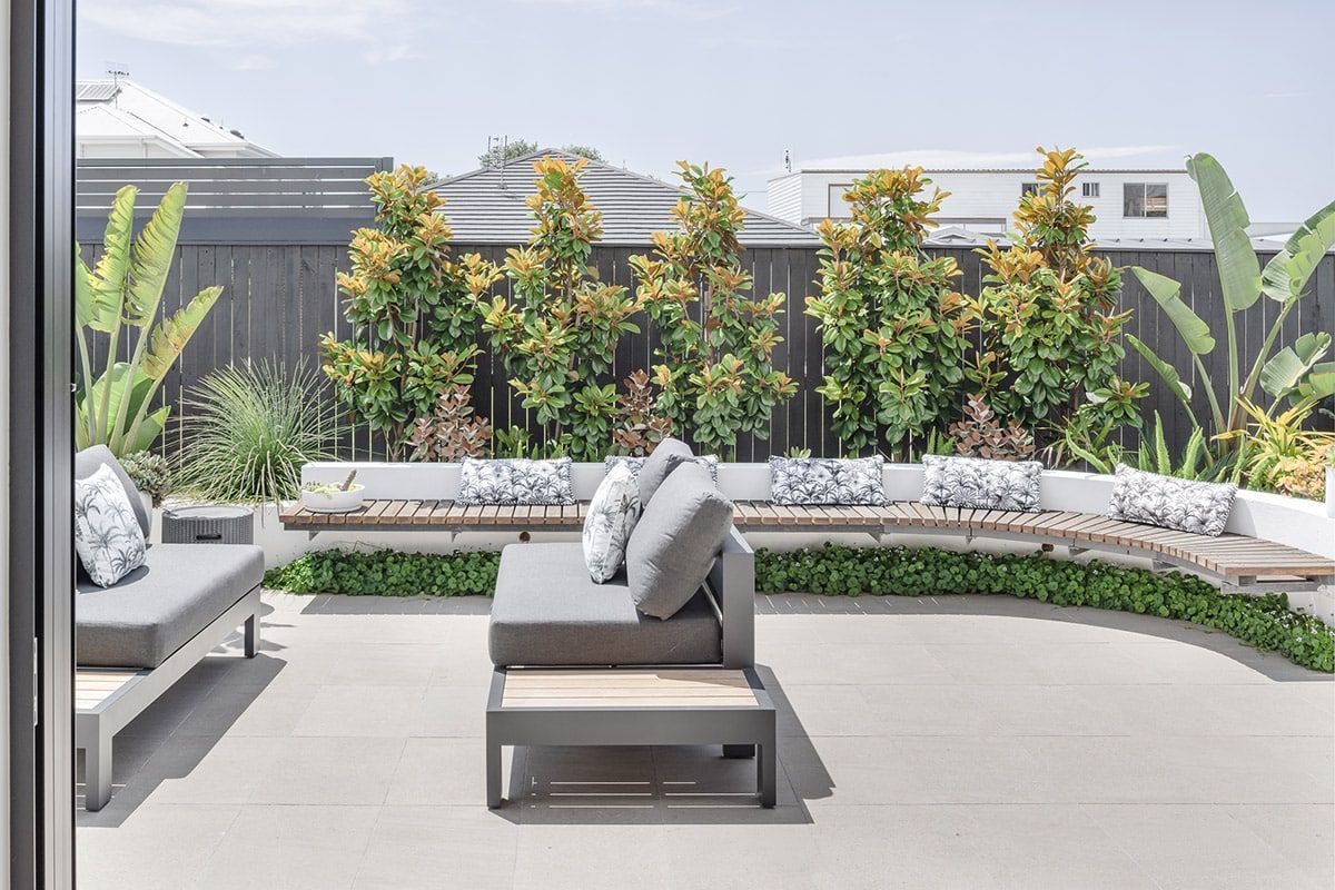 A Patio With A Couch And Chairs And A Sliding Glass Door — QBC Constructions In Werri Beach, NSW