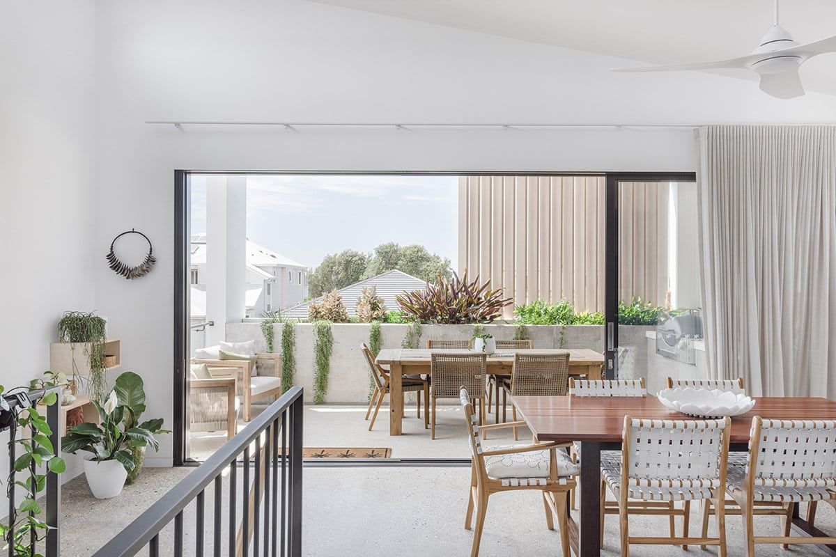 A Dining Room With A Table And Chairs And A Balcony — QBC Constructions In Werri Beach, NSW