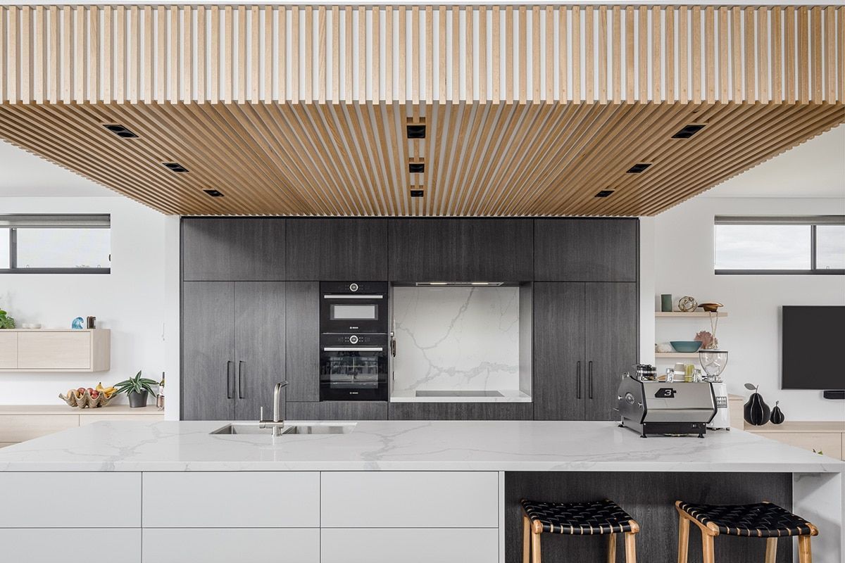 A Kitchen With A Wooden Ceiling And White Cabinets — QBC Constructions In Werri Beach, NSW