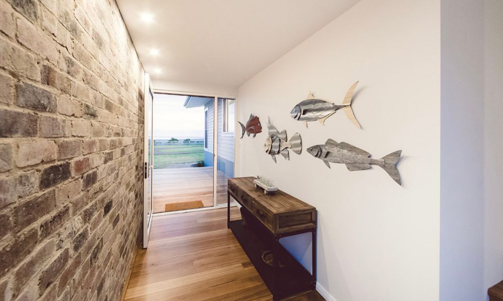 A Hallway With a Brick Wall and Fish on the Wall — QBC Constructions In Willow Vale, NSW