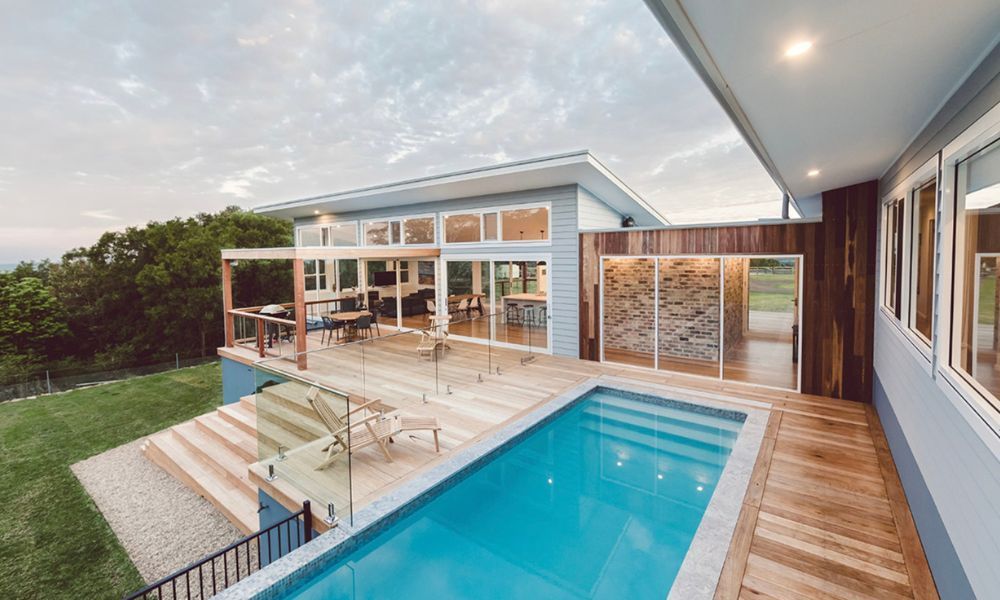 A Large House With a Swimming Pool in Front of It — QBC Constructions In Willow Vale, NSW
