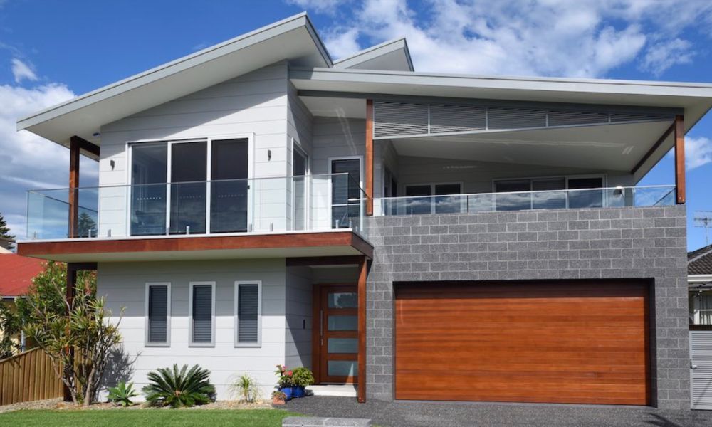 A Large White House With a Wooden Garage Door — QBC Constructions In Gerringong, NSW