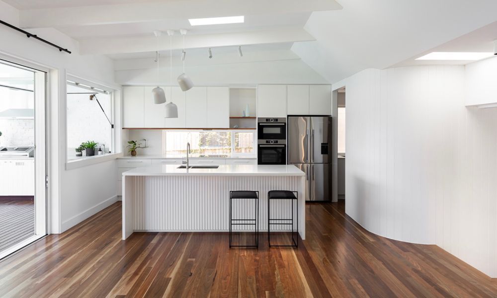 A Kitchen With Wooden Floors and White Cabinets — QBC Constructions In Pacific Avenue, QLD