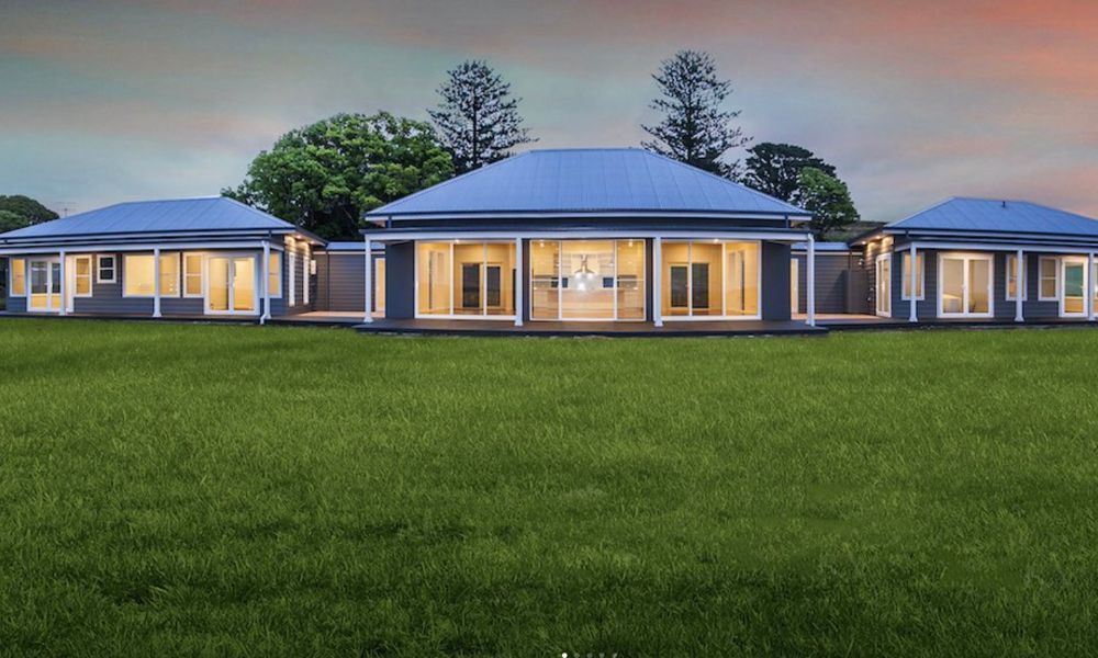 A Large House is Sitting on Top of a Lush Green — QBC Constructions In Gerringong, NSW