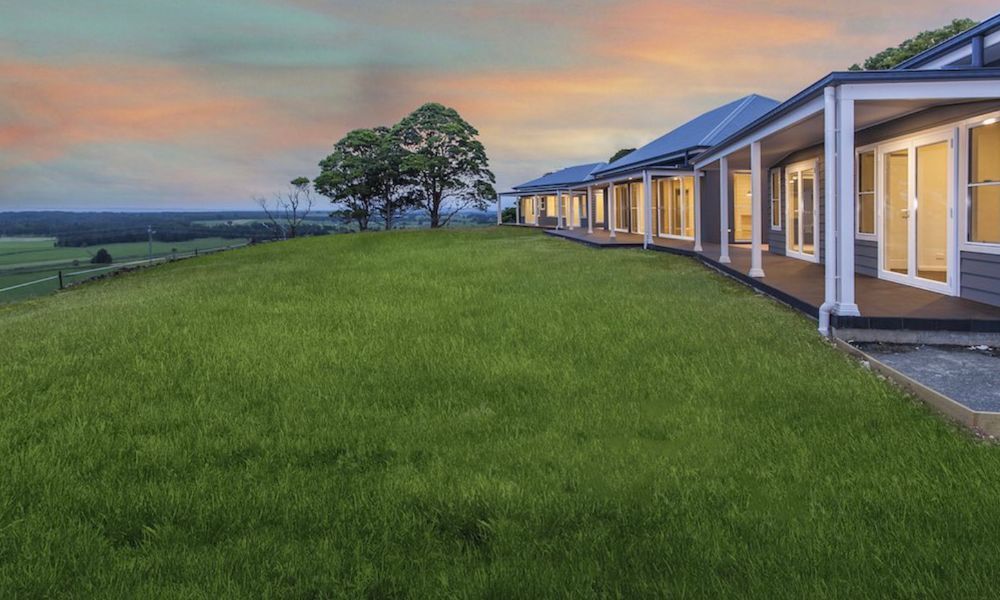 A Row of Houses Sitting on Top of a Lush Green — QBC Constructions In Gerringong, NSW
