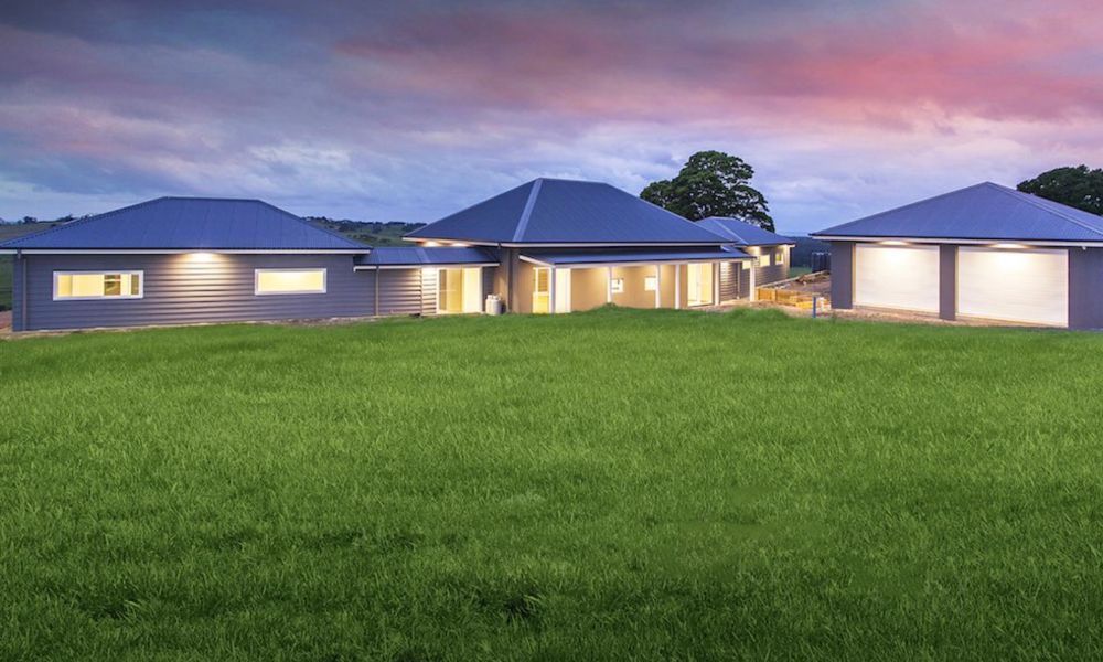 A Large House is Sitting on Top of a Lush Green — QBC Constructions In Gerringong, NSW