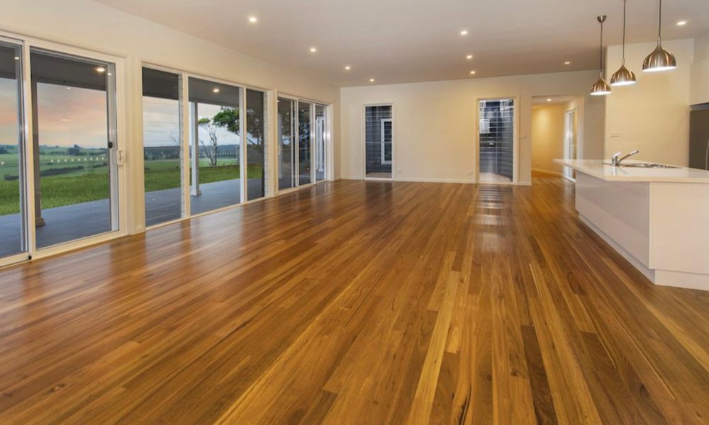A Large Empty Room With Hardwood Floors — QBC Constructions In Gerringong, NSW