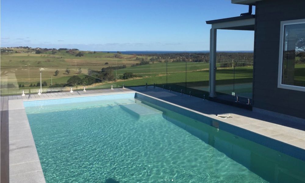 A Large Swimming Pool With a View of a Field and the Ocean — QBC Constructions In Gerringong, NSW