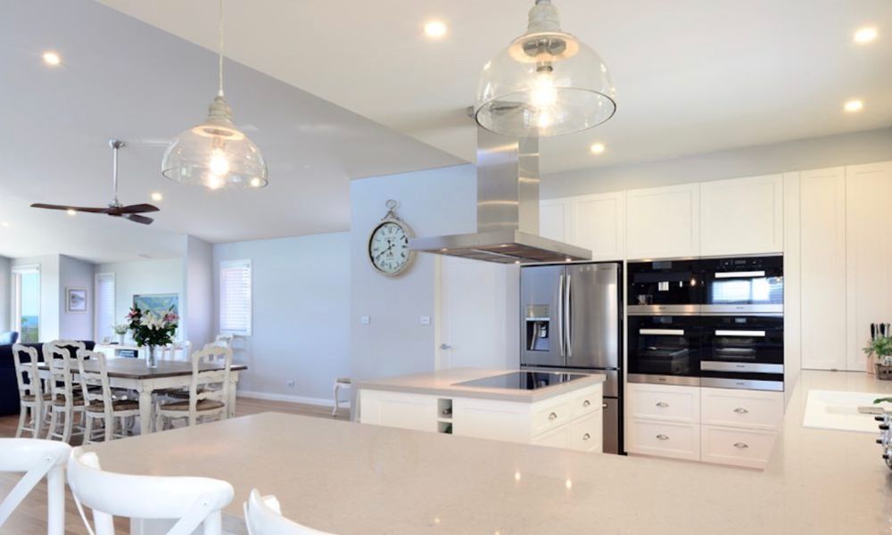 A Kitchen With White Cabinets and a Clock on the Wall — QBC Constructions In Gerringong, NSW