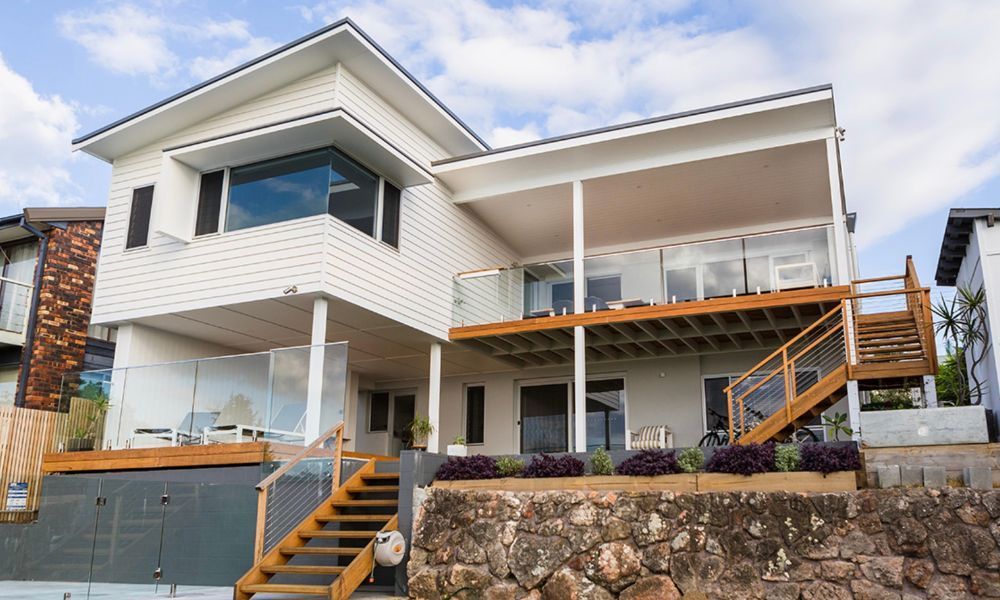 A Large White House With Stairs Leading Up to the Second Floor — QBC Constructions In Gerringong, NSW