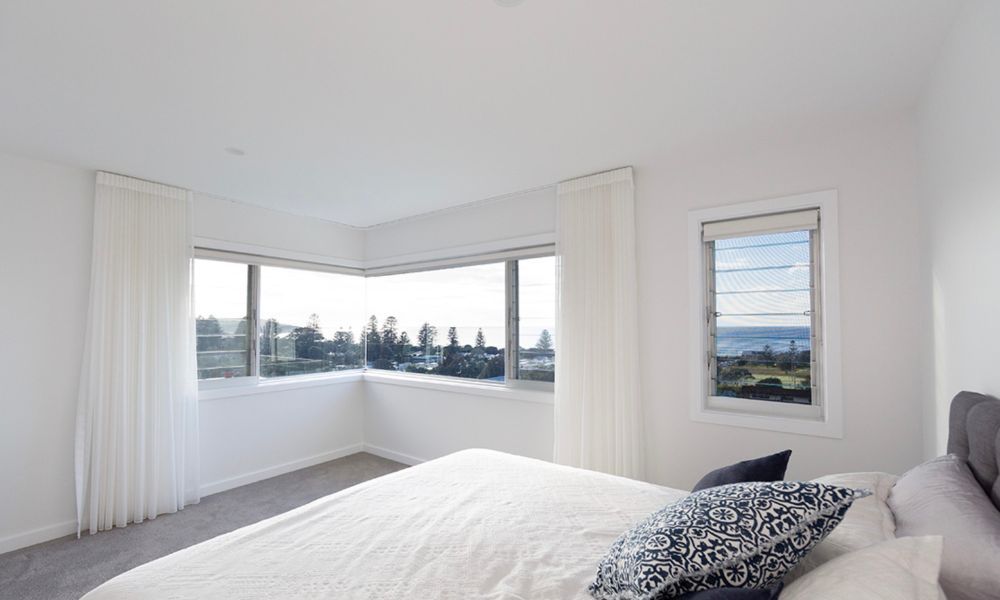 A Bedroom With a Large Bed — QBC Constructions In Gerringong, NSW