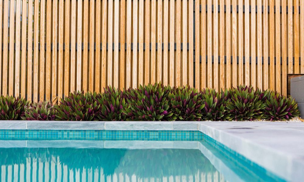 A Swimming Pool With a Wooden Fence — QBC Constructions In Gerringong, NSW