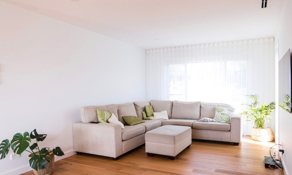 A Living Room With a Large Sectional Couch and Ottoman — QBC Constructions In Gerringong, NSW