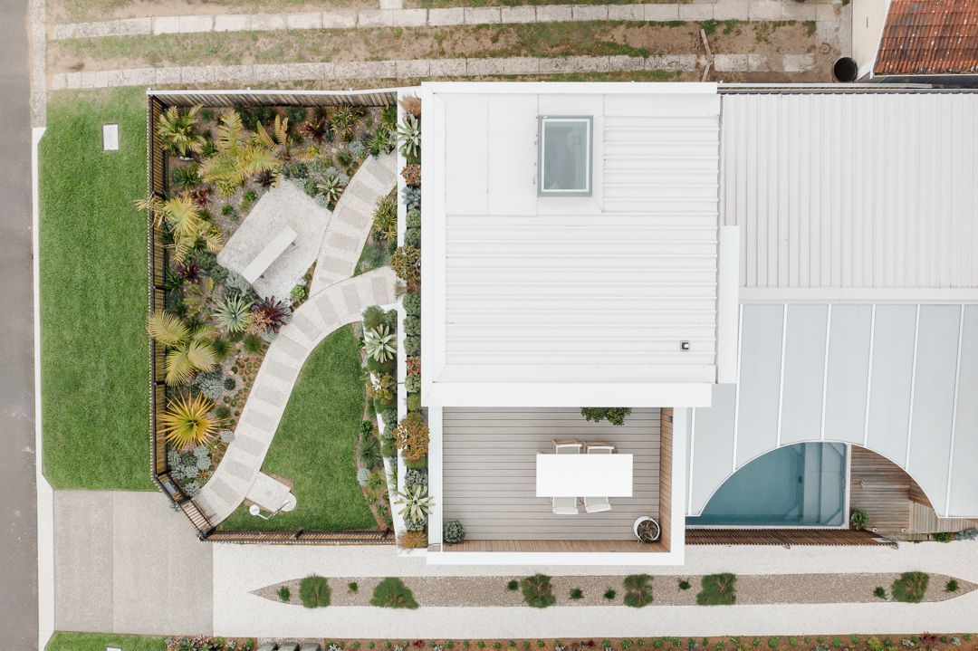 An Aerial View of a White House With a Table and Chairs in the Backyard — QBC Constructions In Werri Beach, NSW