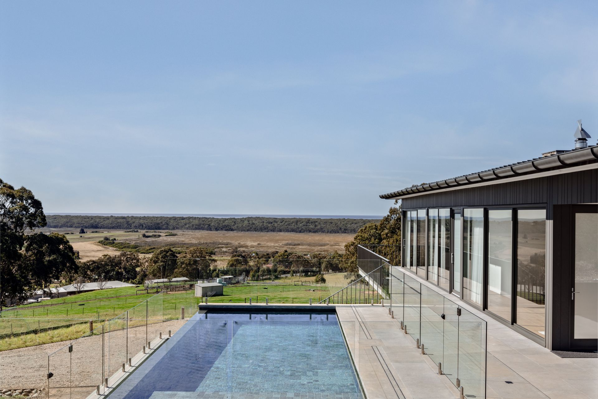 A Large Swimming Pool is Surrounded by a Glass — QBC Constructions In Seven Mile Beach, NSW