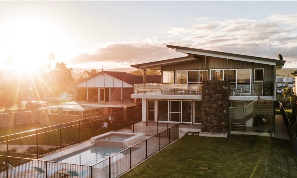 An aerial view of a large house with a swimming pool in the backyard.