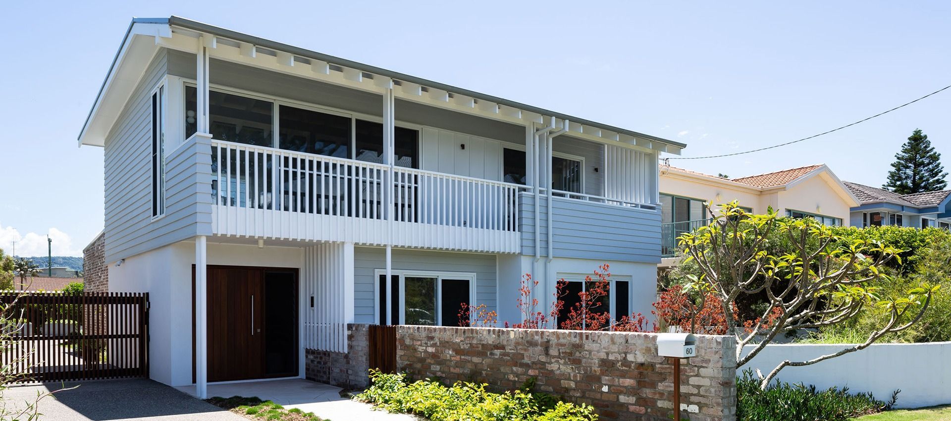 A White House With a Balcony and a Fence in Front of It
— QBC Constructions In Werri Beach, NSW