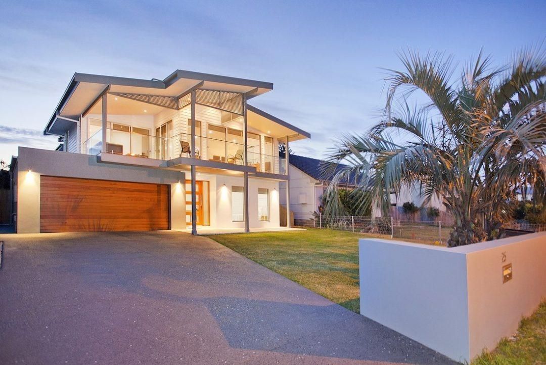 A Large Modern House With a Lot of Windows — QBC Constructions In Werri Beach, NSW