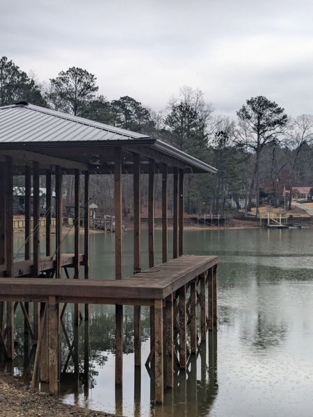 A wooden dock overlooking a lake with trees in the background