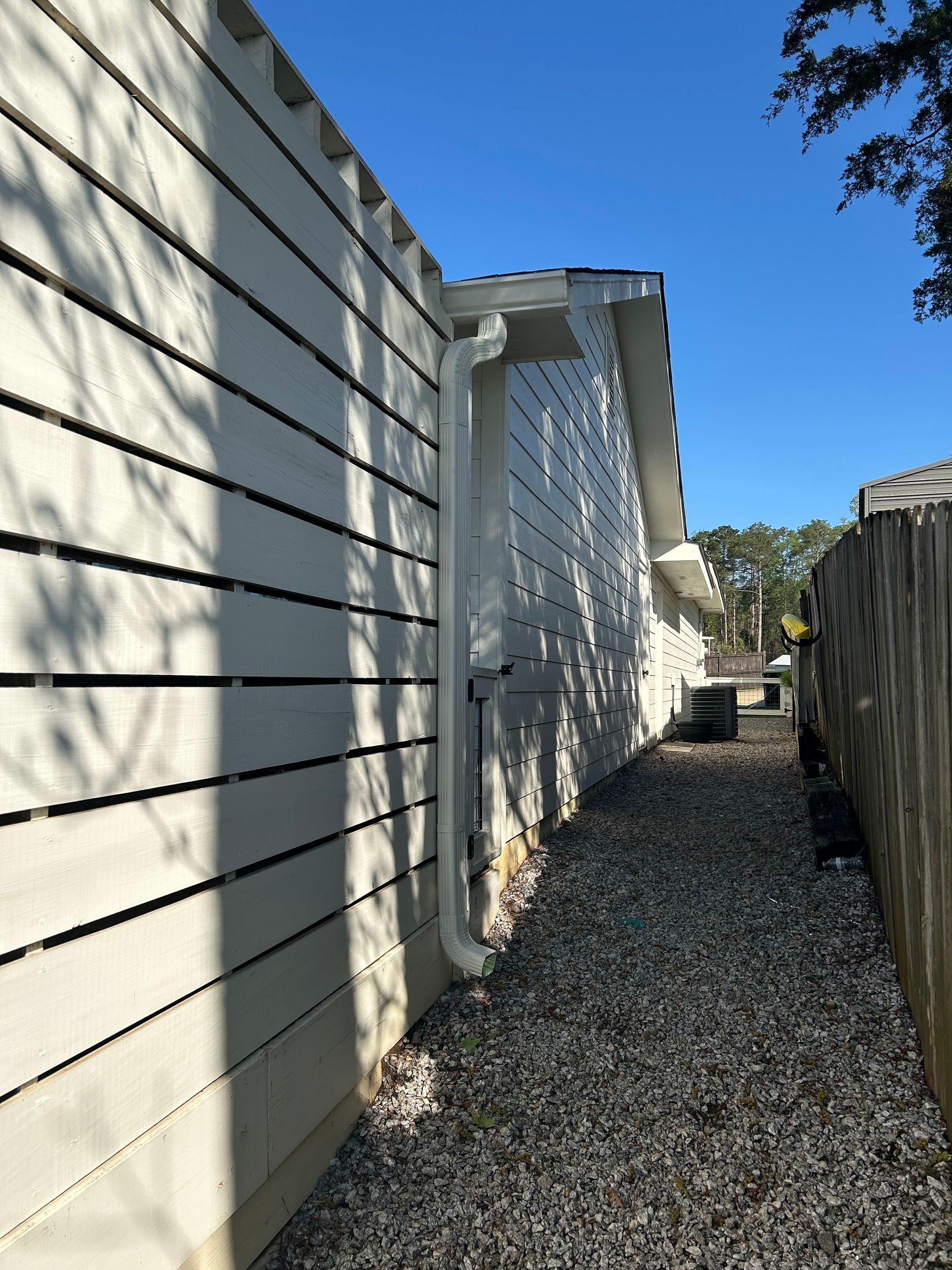 A white house with a gutter on the side of it