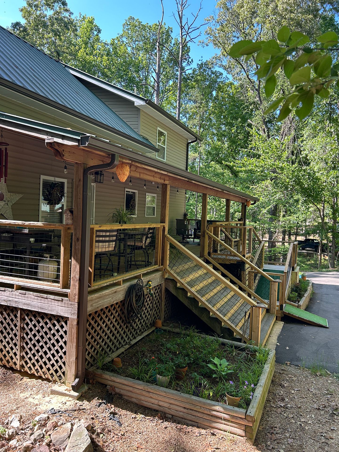 Wooden porch and stairs on a rustic house surrounded by trees and greenery