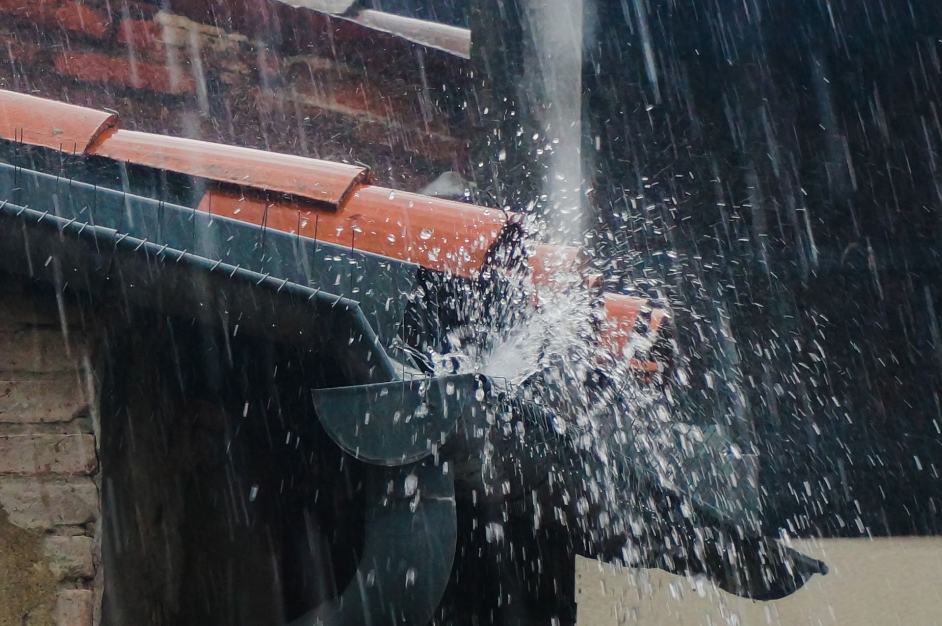 Water is Coming Out of a Gutter on a Roof in the Rain